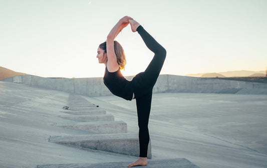 A person doing yoga on concrete.