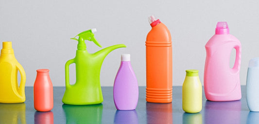 A row of colorful laundry detergent bottles against a grey background.