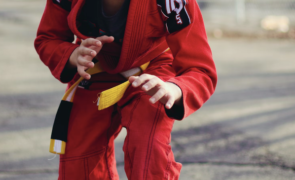 Young athlete wearing a red gi with a yellow belt
