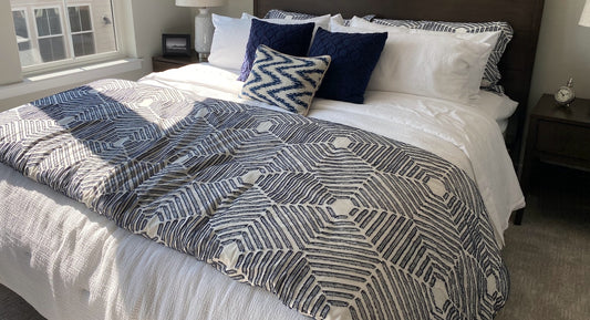 A patterned weighted blanket on a cleanly made bed.